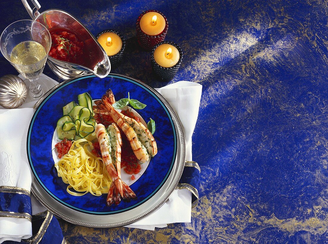 Jumbo prawns with tomato sauce, noodles and strips of courgette