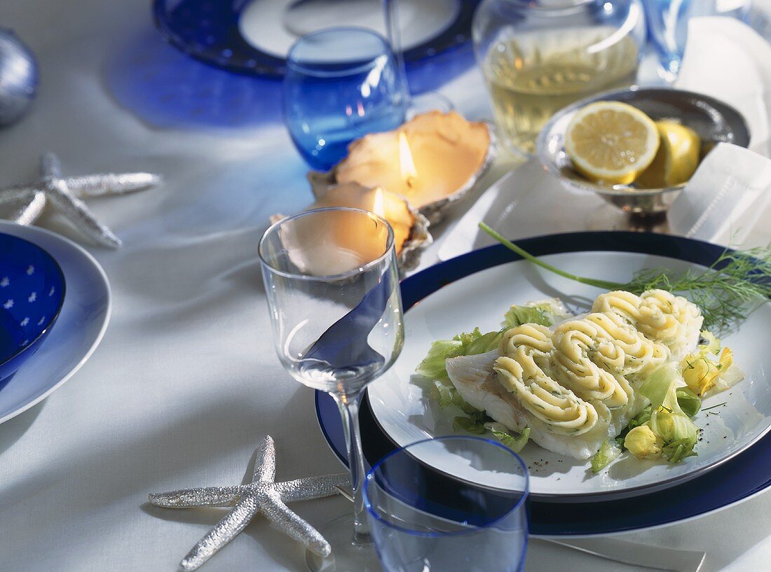 Fischfilets mit Kartoffelpüree und Salat auf Weihnachtstisch