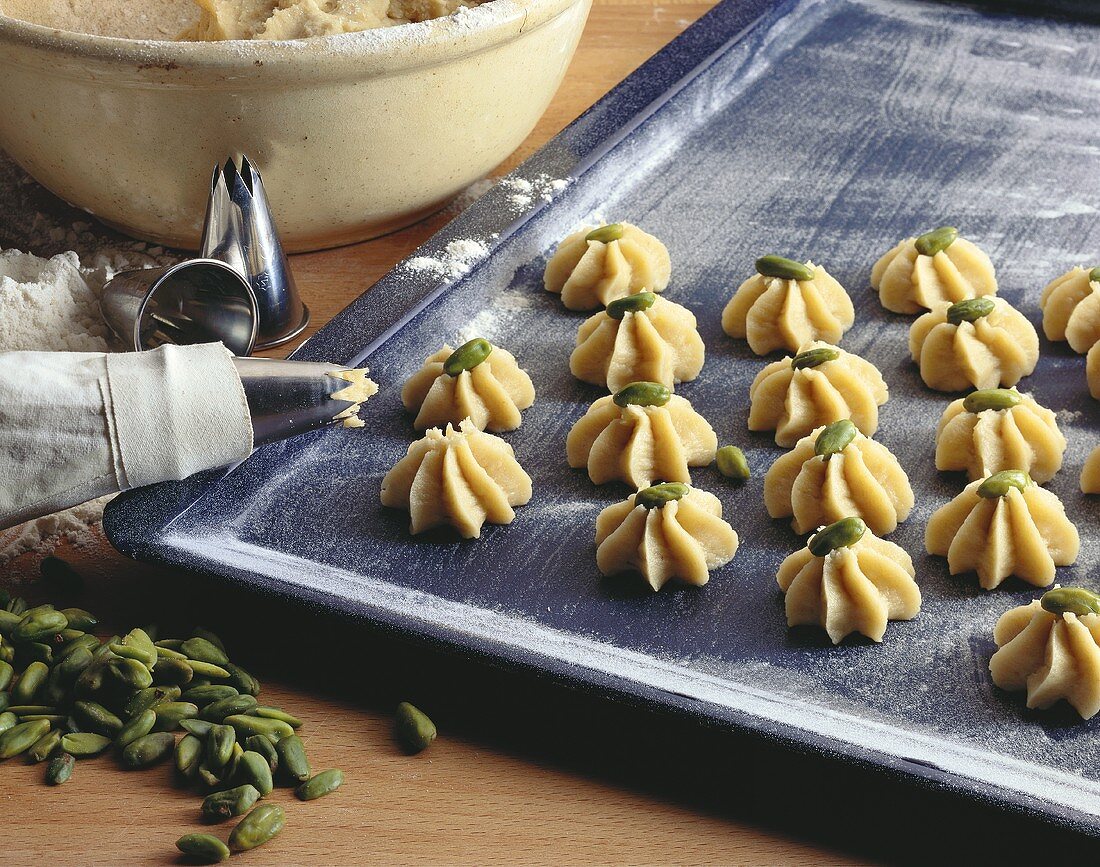 Teig für Pistazienplätzchen auf Backblech aufspritzen