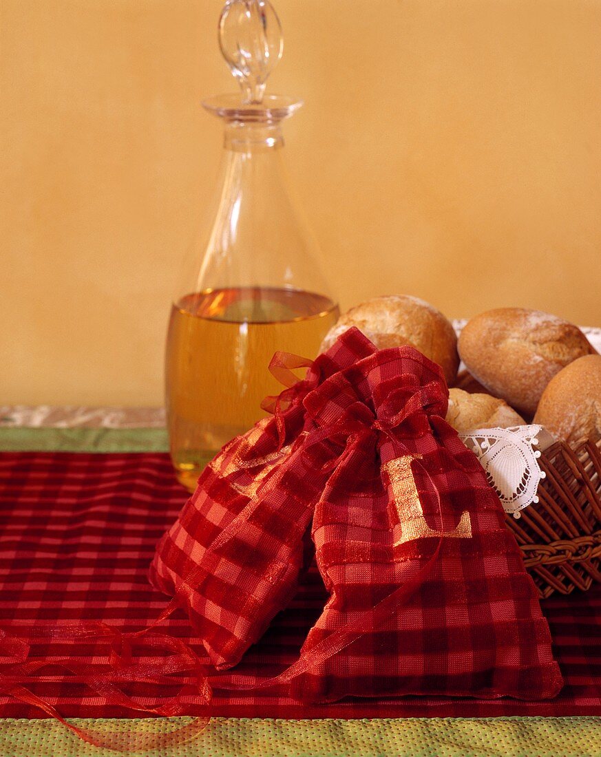 Bread rolls in a bread basket with two red fabric bags