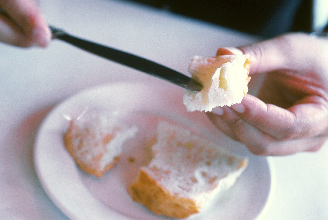 Butter auf Weißbrot streichen