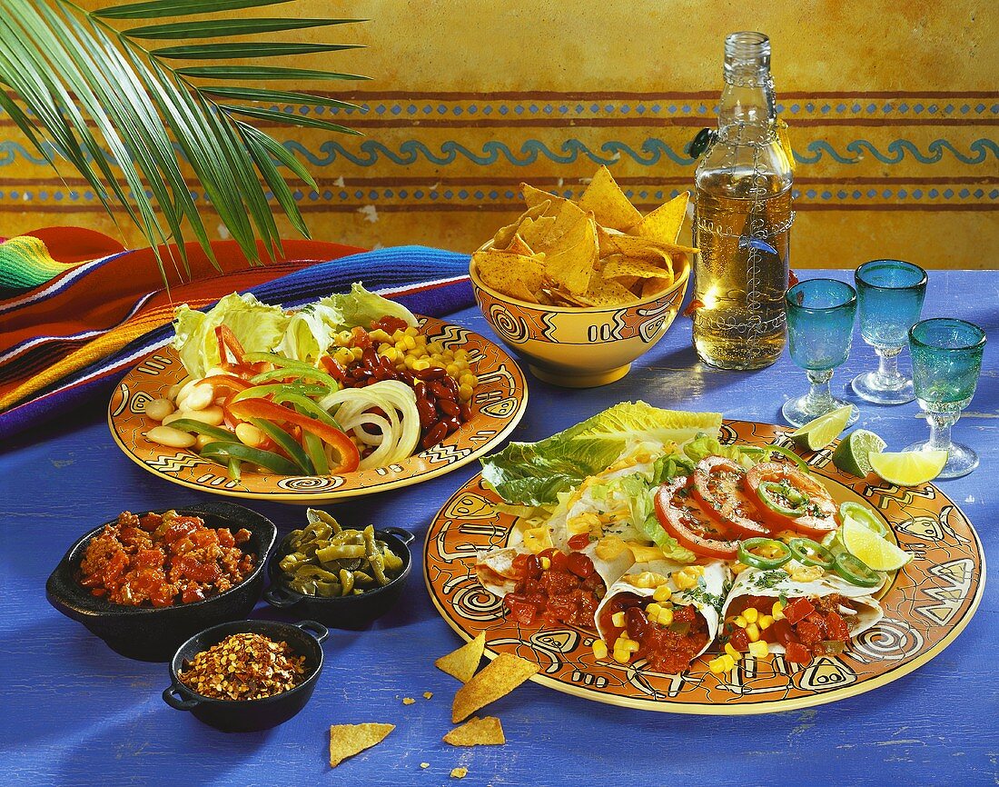 Various Mexican appetisers: tortillas, salad, crisps