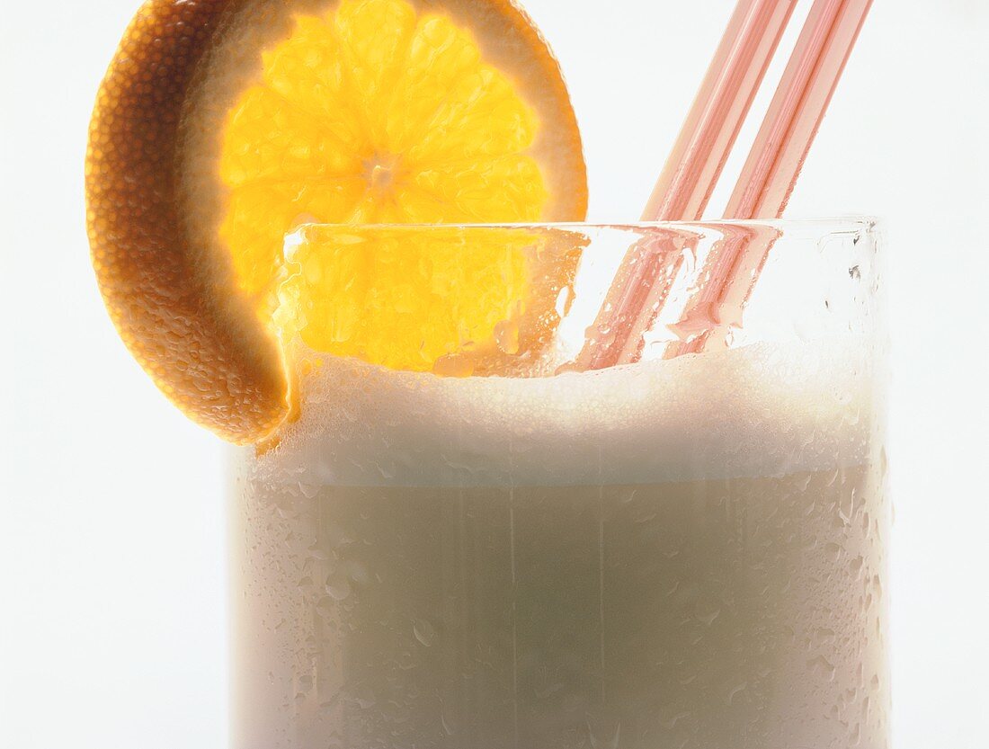 Milchshake mit Orangenscheibe und Strohhalmen