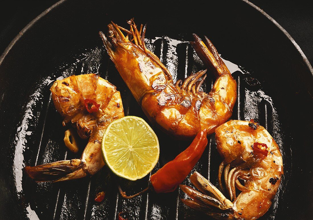 Jumbo prawns with chili pepper and lime in grill pan