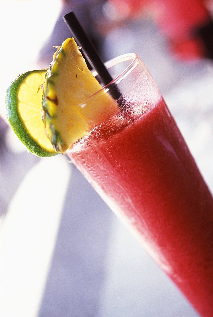 Strawberry juice with pineapple and lime in a glass