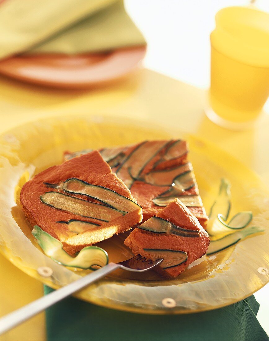 Kürbis-Frittata mit Zucchinistreifen auf gelbem Teller