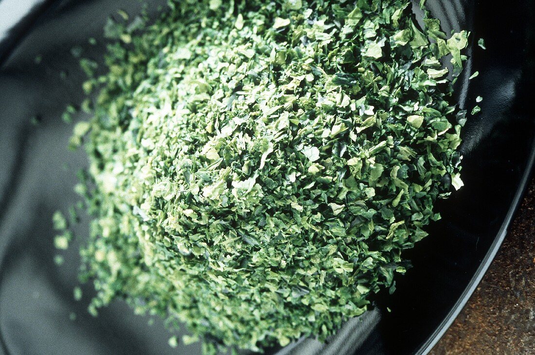 Chopped seaweed on a black plate