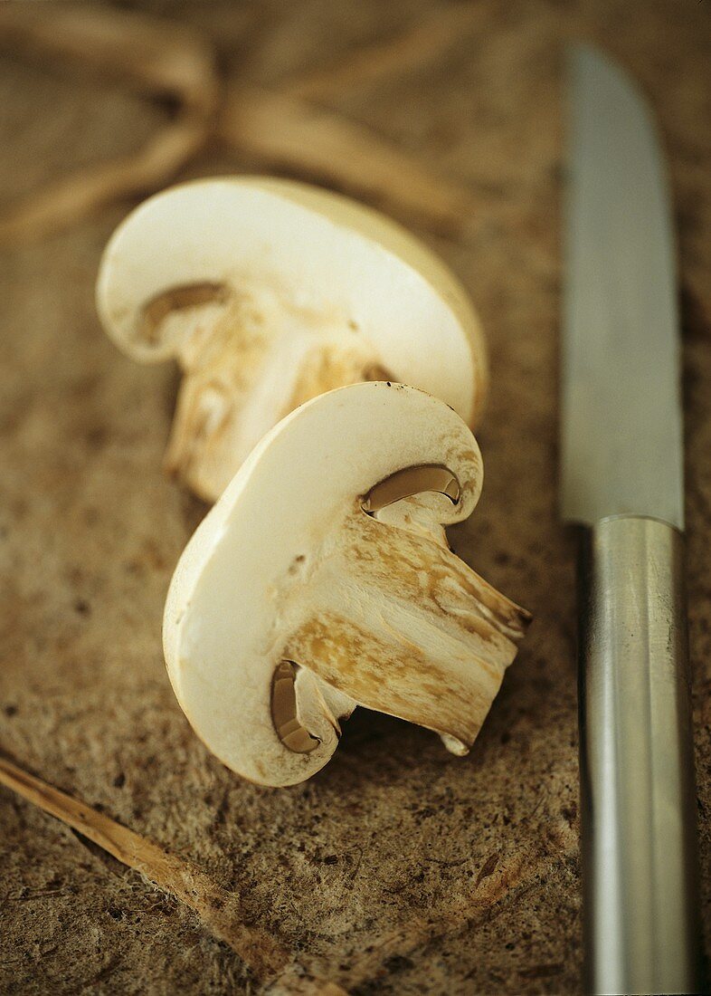 Two slices of mushroom, knife beside them