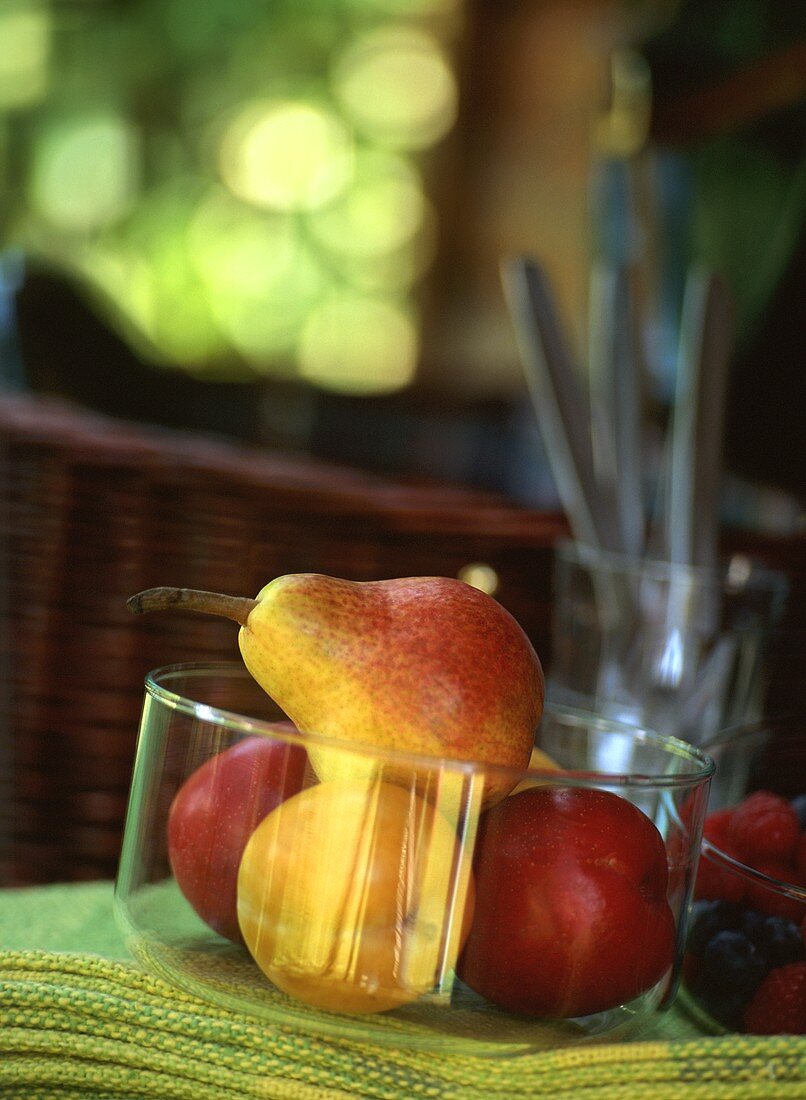Birnen und Äpfel in einer Glasschale auf Tisch