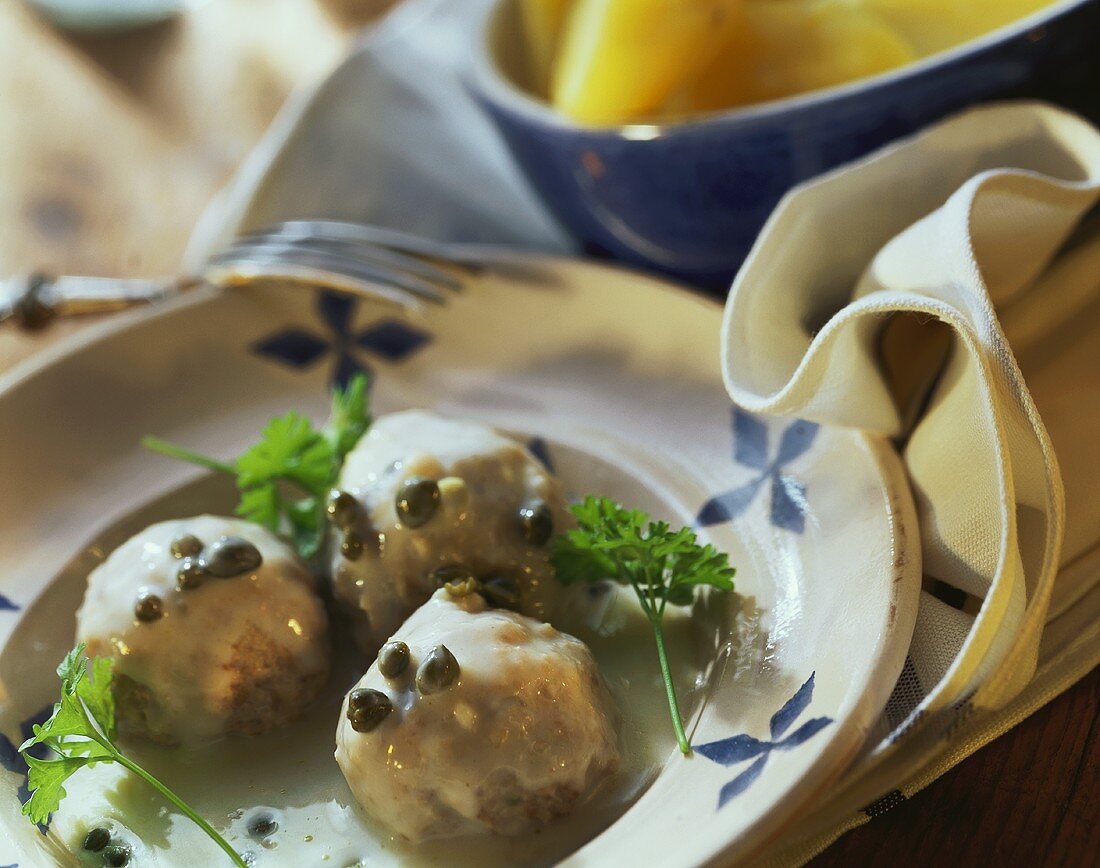 Königsberger meat balls with capers and parsley on plate