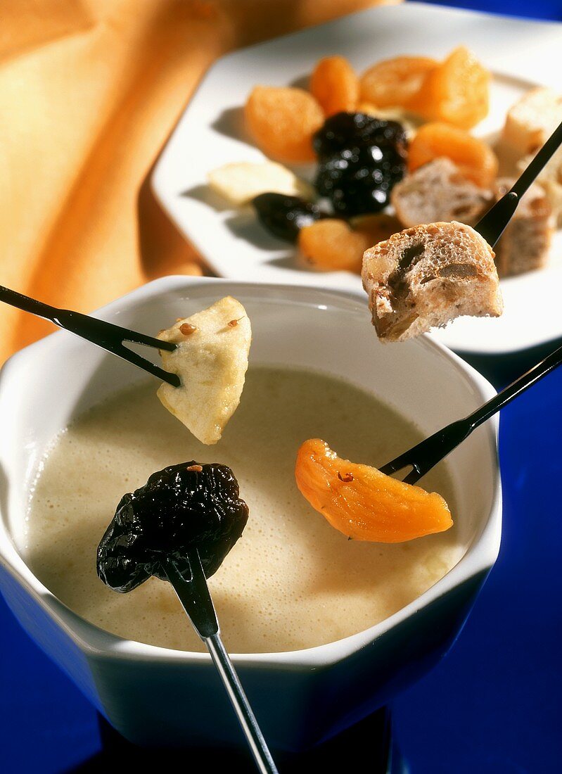 White chocolate fondue with dried fruit and raisin bread