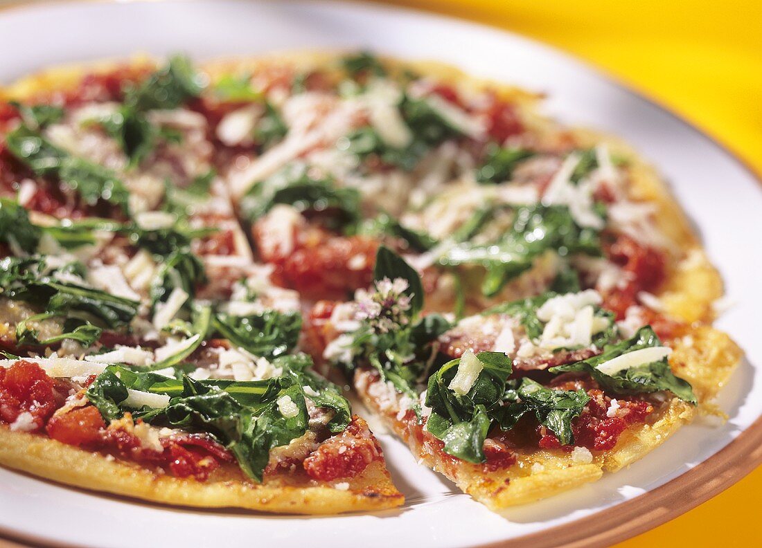 Pizza alla rucola (pizza with salami, rocket and Parmesan)