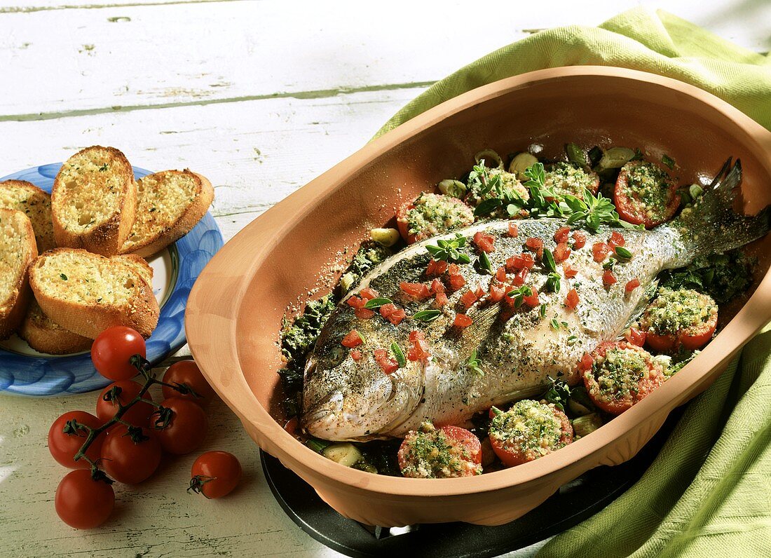 Gilthead bream with tomatoes and herbs in Römertopf