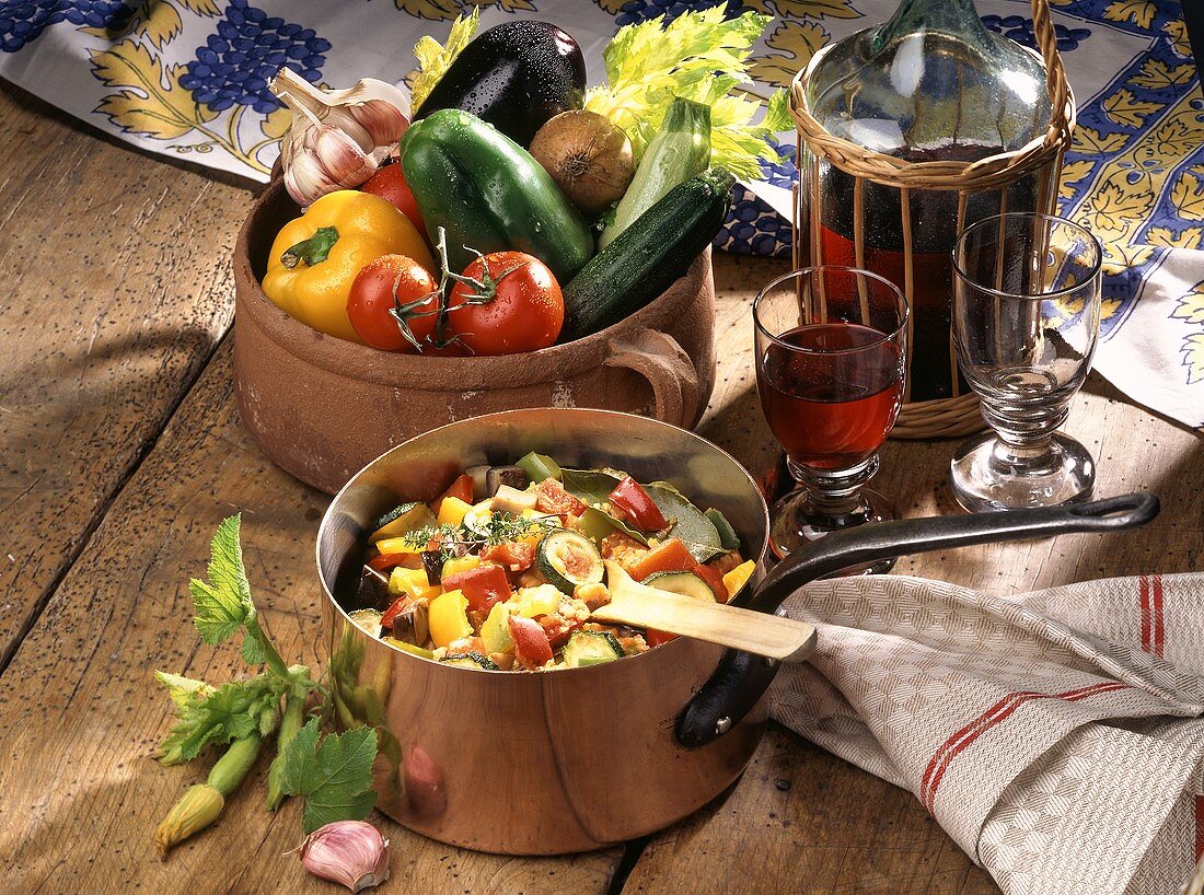 Ratatouille in a copper pan;  fresh vegetables; red wine