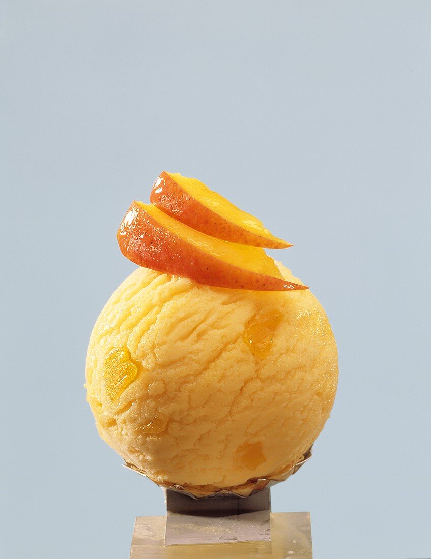 A scoop of mango ice cream with mango segments