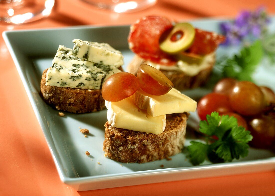 Walnut ring snacks, topped with cheese, tomatoes etc.