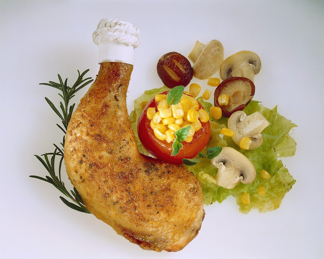 Chicken leg with stuffed tomato, salad and mushrooms