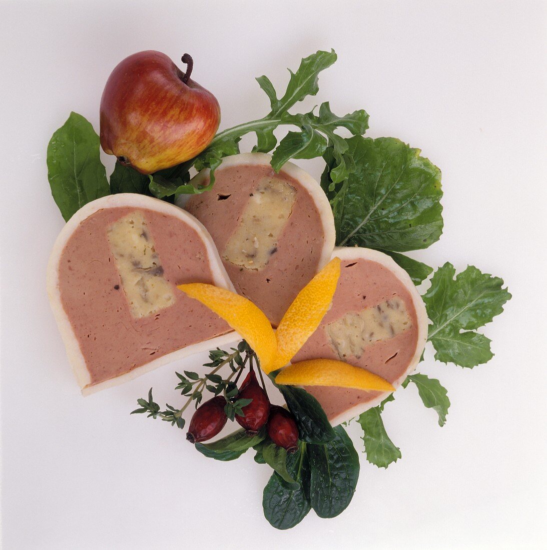 Three slices of liver pate with apple, garnished with salad