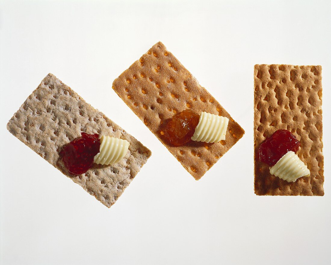 Drei Knäckebrote mit Marmelade und Butter