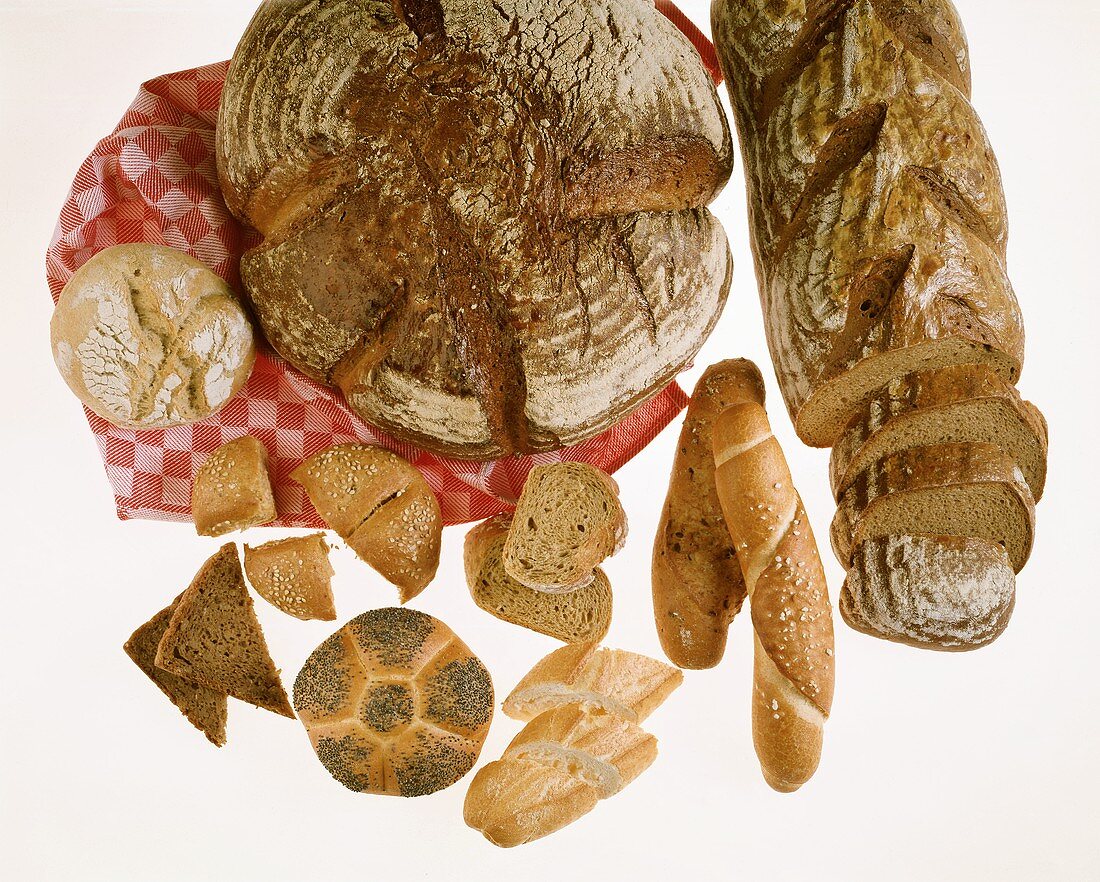 Various breads and rolls on checked tea towel