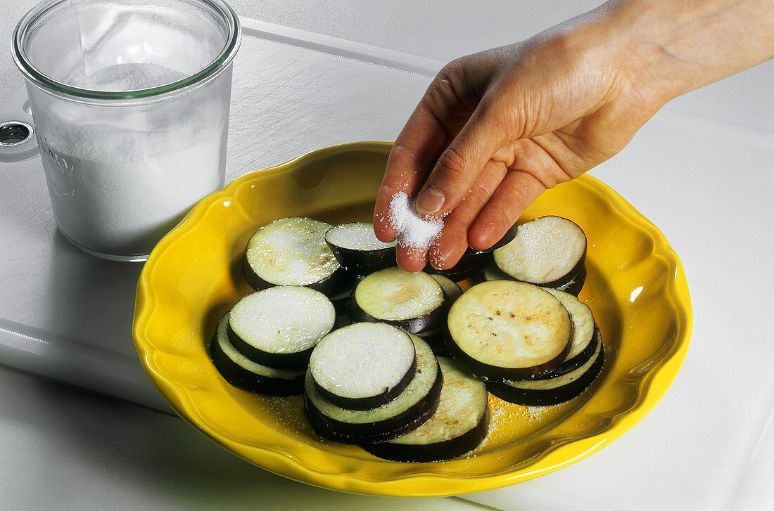 Sprinkling aubergine slices with salt