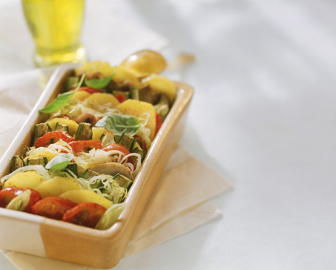 Gemüse-Kartoffel-Gratin mit Olivenöl in der Auflaufform