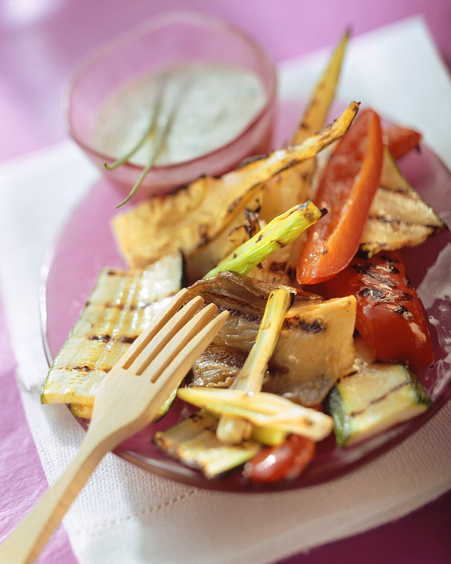 Grilled vegetables with herb yoghurt sauce on plate