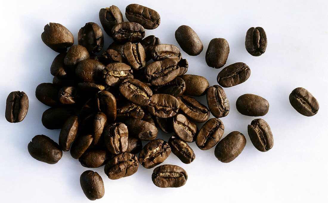 A heap of coffee beans on light background