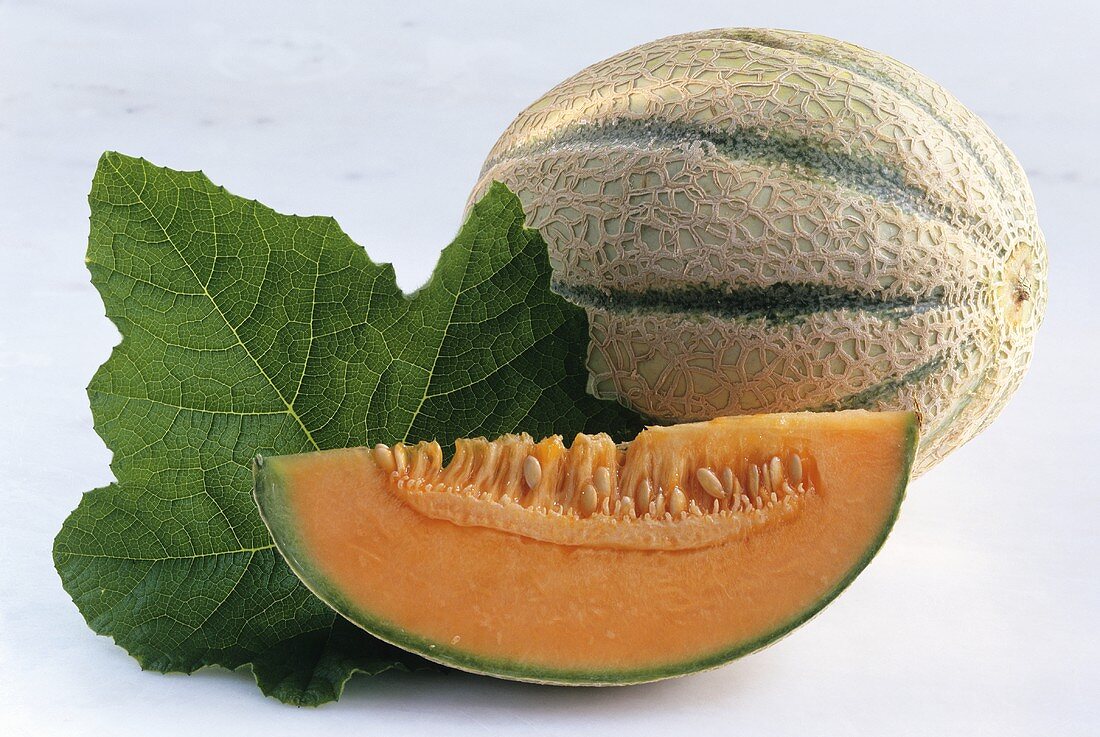 Charentais melon with melon slice and leaf