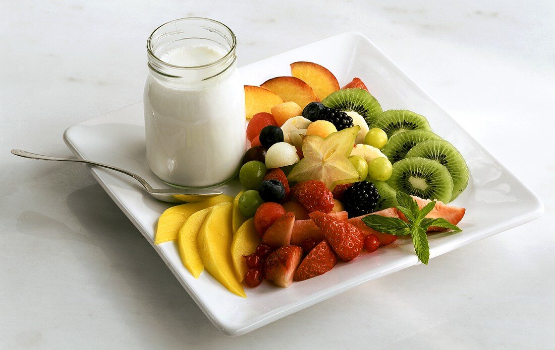 Obstsalat mit einem Glas Joghurt