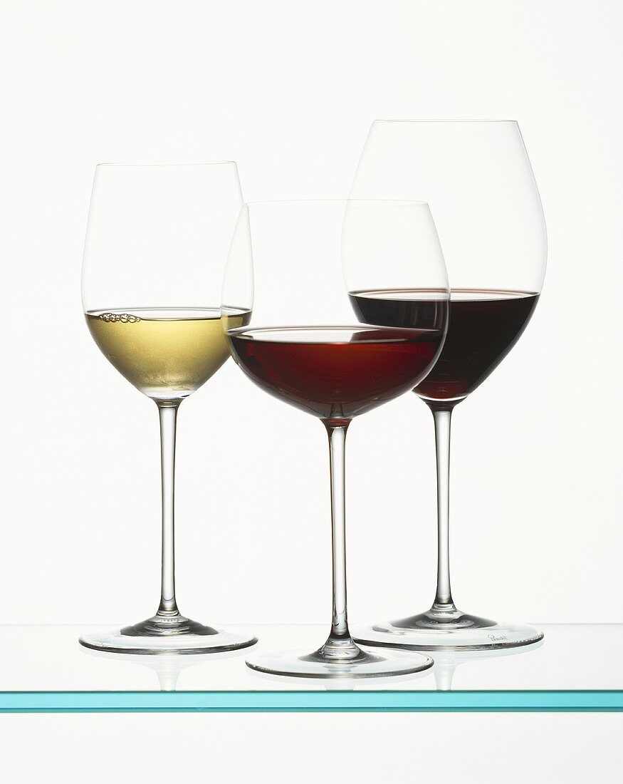 Zwei Rotweingläser und ein Weissweinglas