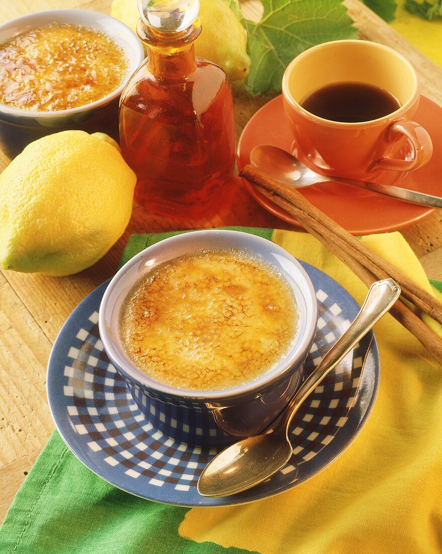 Crème brulee in bowl; cinnamon sticks; coffee cup