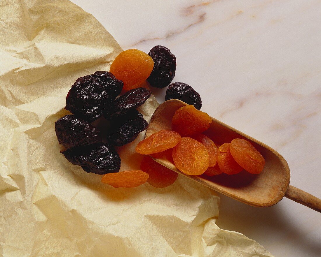 Getrocknete Aprikosen und Pflaumen, teilweise auf Schaufel