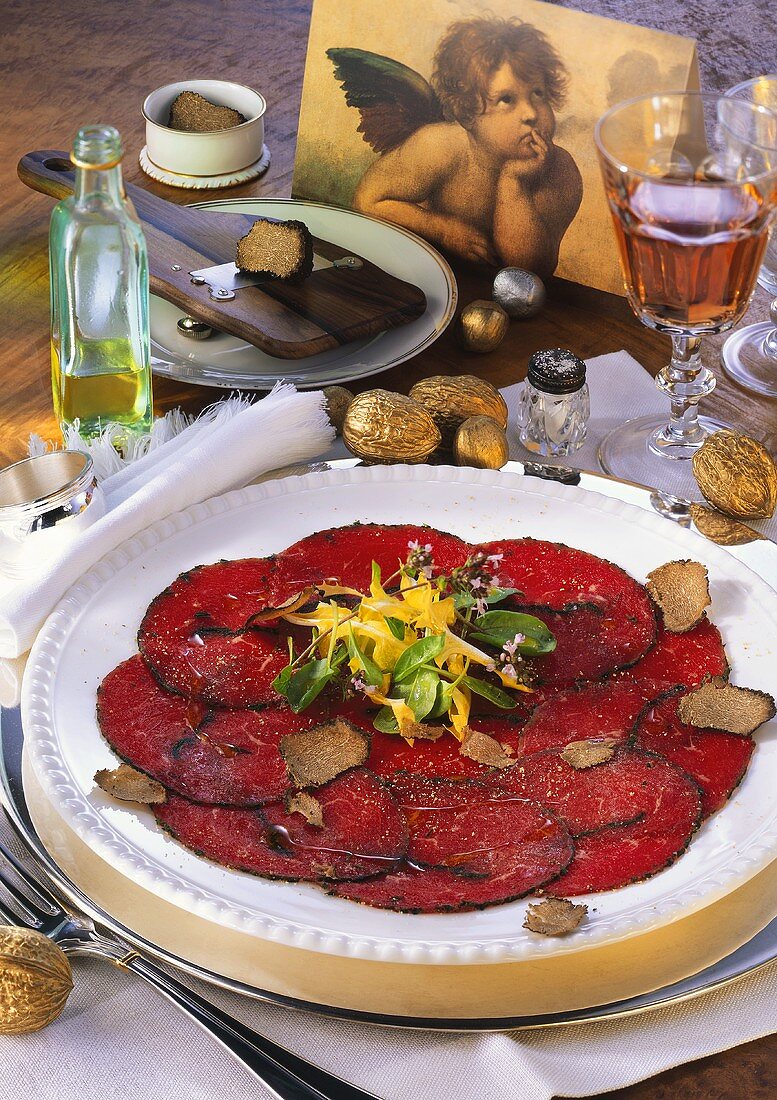 Beef carpaccio with truffles, garnished with herbs