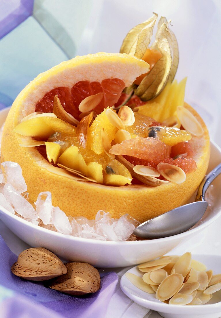 Exotic fruit with almonds in grapefruit half on ice