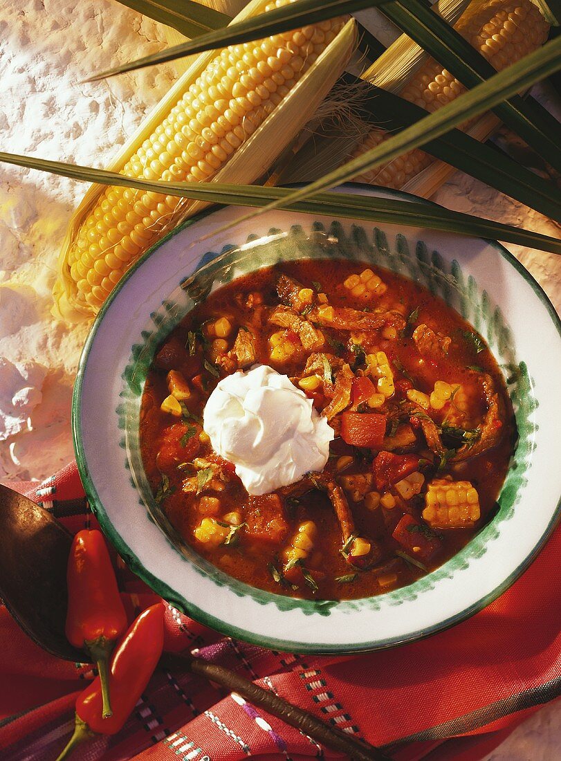 Chili with sweet corn and crème fraiche on plate