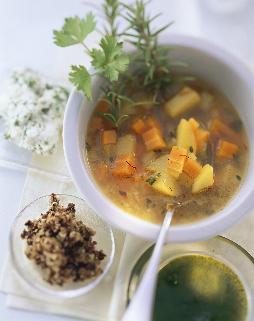 Vegetable soup with chopped olives, rosemary, herb mousse