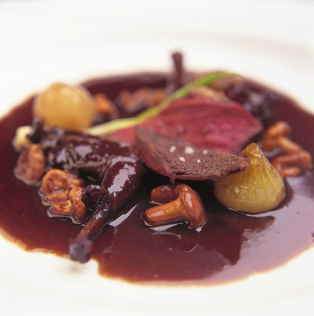 Pink roast pigeon with chanterelles in red wine sauce