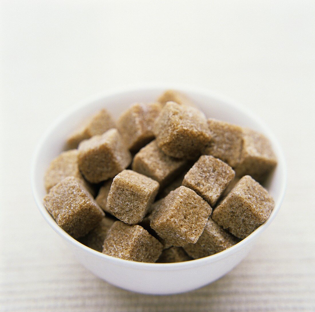 Brown sugar cubes in white bowl