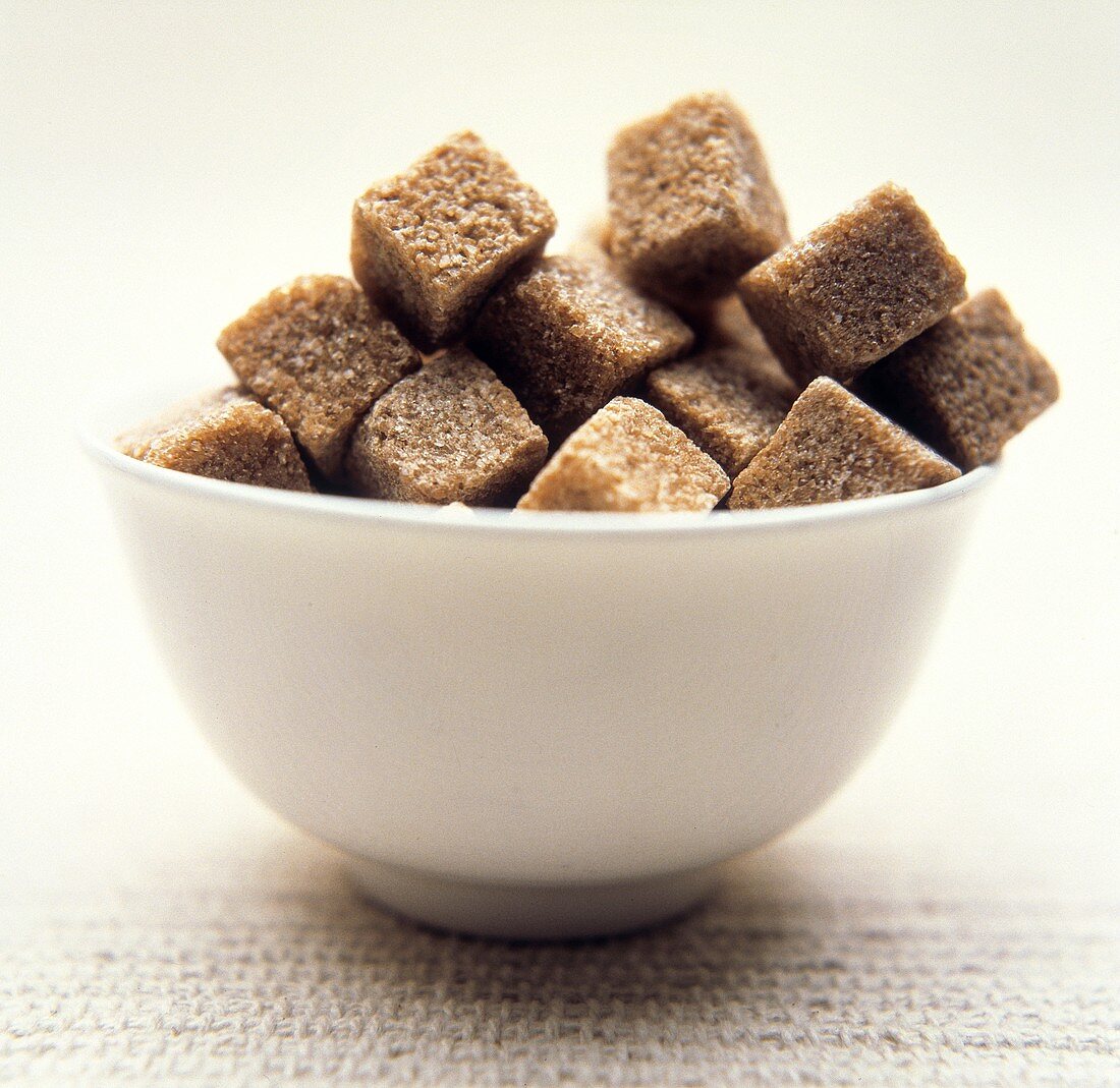 Brown sugar cubes in white bowl