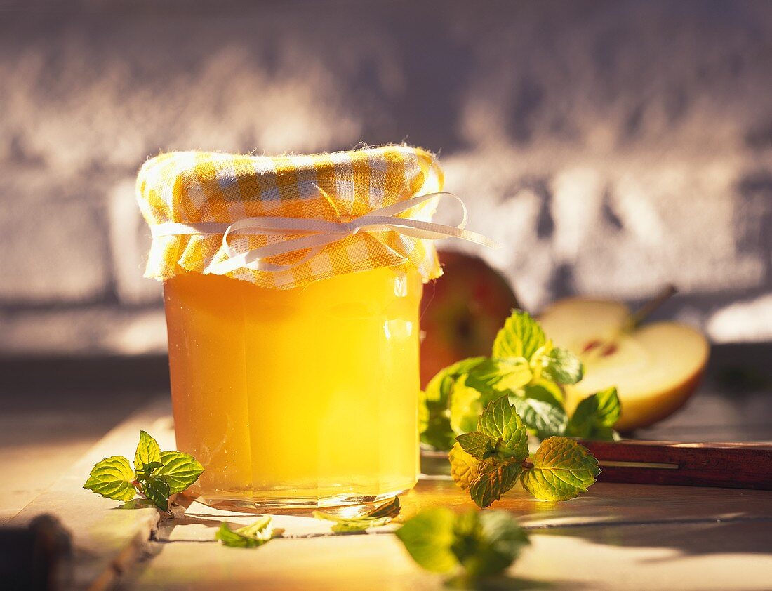 Clear mint jelly with apples in jam jar