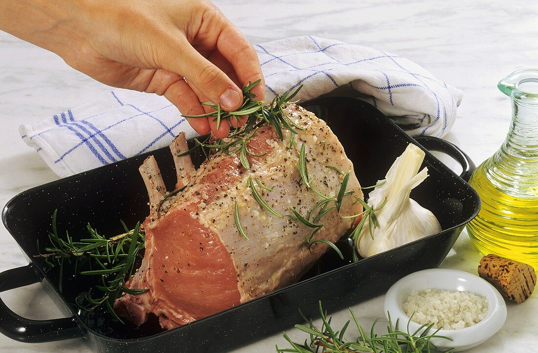 Sprinkling meat with fresh rosemary