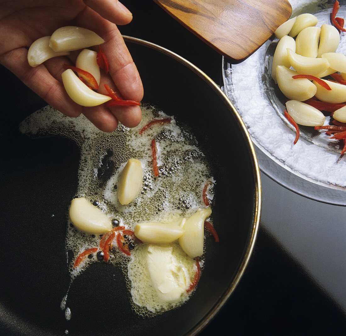 Sautéing cloves of garlic in butter