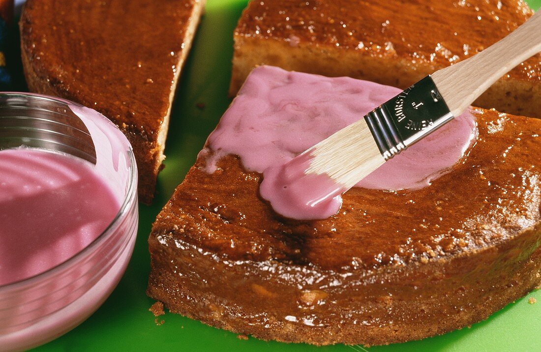 Gebackenen Kuchen (Pink Käfer) mit Zuckerglasur bestreichen