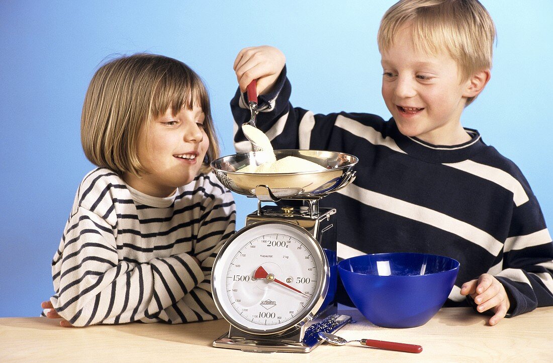 Two children weighing out semolina