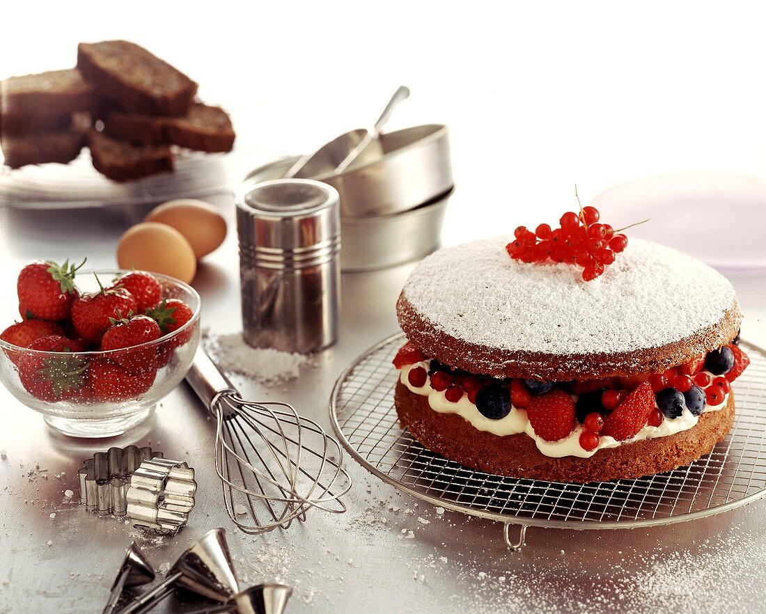 Schokoladenkuchen mit Sahne-Beeren-Füllung; Backutensilien