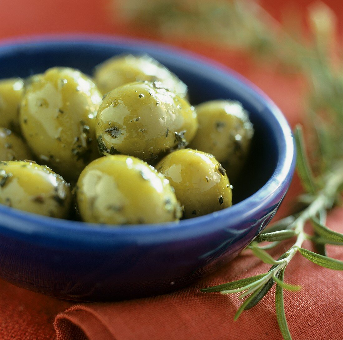 Bottled green olives in a blue bowl