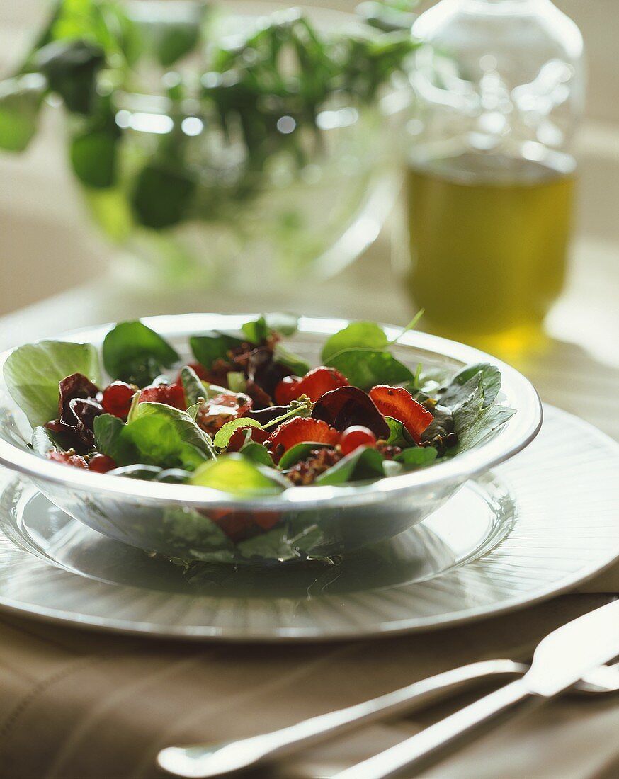 Gemischter Salat mit Erdbeeren auf Glasteller