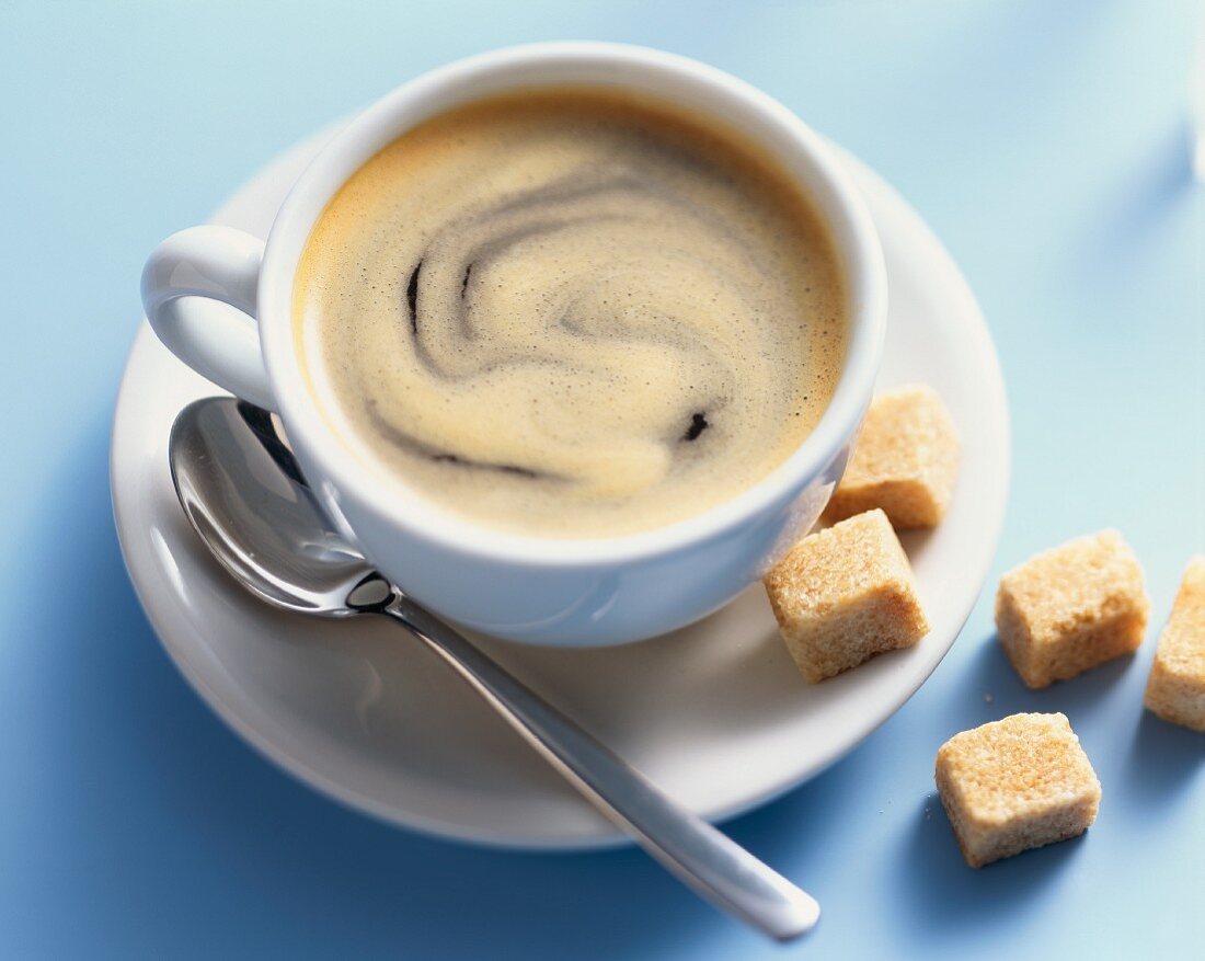 Eine Tasse Caffe Crema und Rohzuckerwürfel