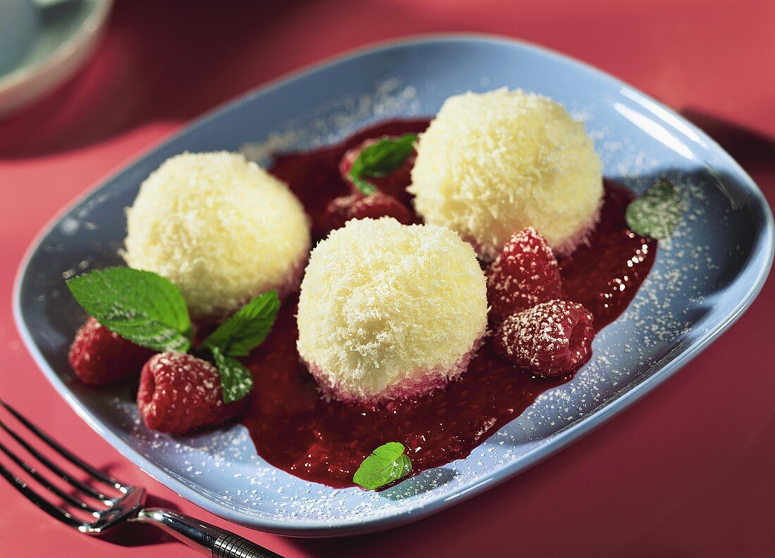 Coconut balls with raspberry sauce and fresh mint